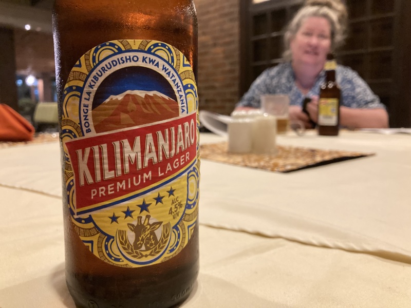 Kilimanjaro Premium Lager on a table with a seated woman in the distance