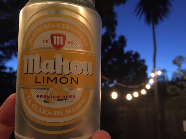 Mahou Limón beer can outdoors under a palm tree