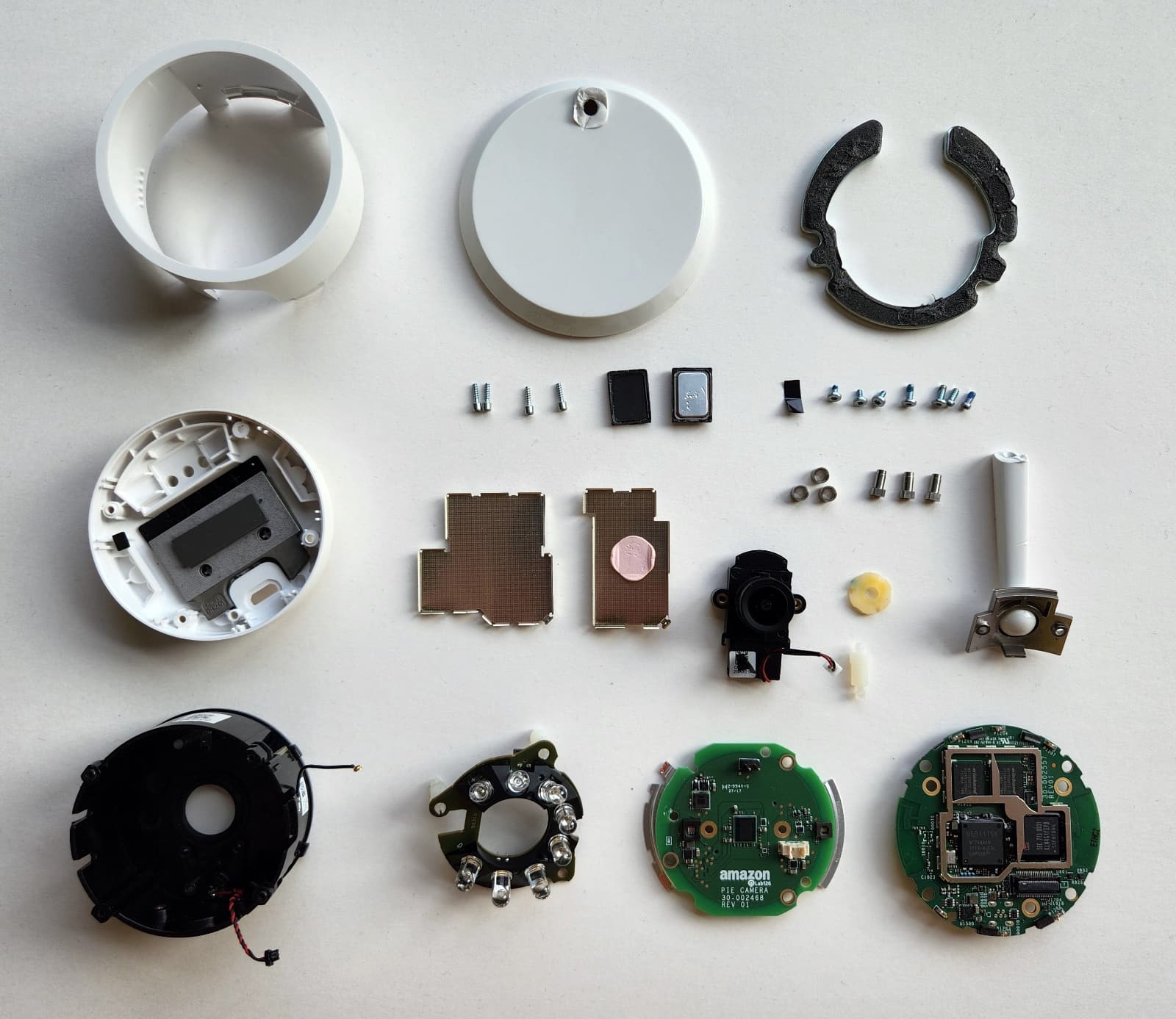Cloud Cam components: 5 body pieces, 3 circuit boards, 11 screws, a small speaker and grill, 2 heat sinks, and the circuit boards from above