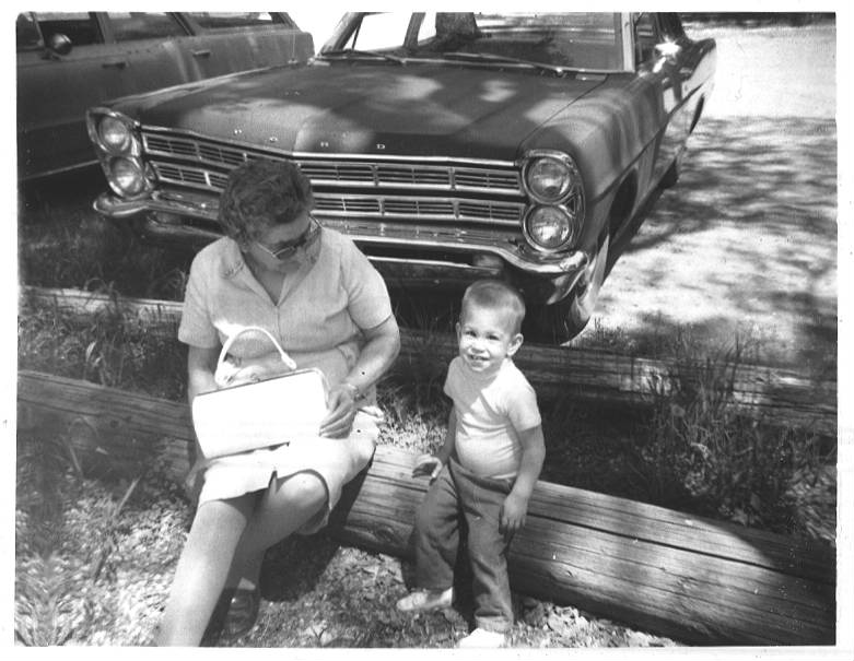 My grandmother and me in front of an old Ford