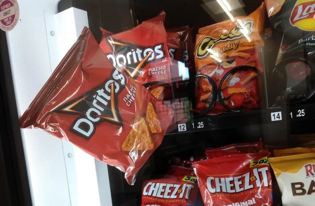 Doritos stuck in a vending machine, hanging on the edge before falling