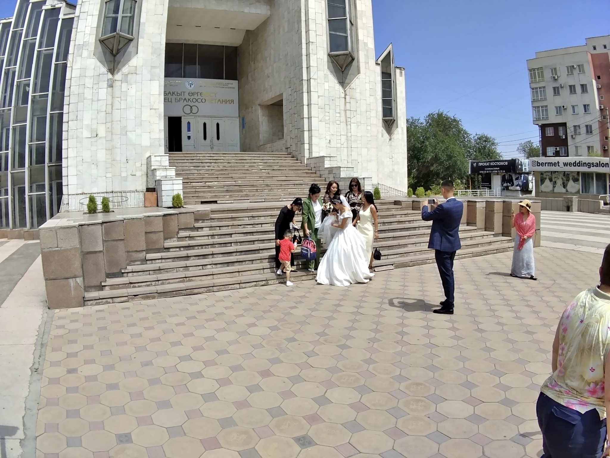 A wedding group in front of a facility